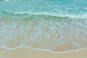 morbido onda di blu oceano su sabbioso spiaggia. estate vacanza nel isola. chiaro azzurro acqua sfondo. foto