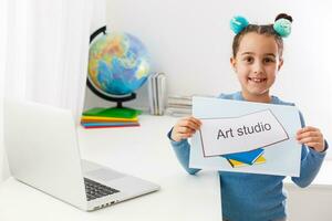 poco ragazza studiando arte studio su il computer portatile in linea, distanza apprendimento foto