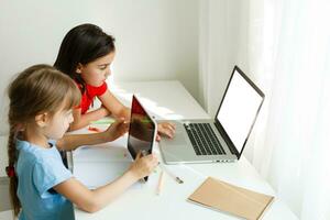 apprendimento a partire dal casa, casa scuola ragazzo concetto. poco bambini studia in linea apprendimento a partire dal casa con il computer portatile. quarantena e sociale distanziamento concetto. foto