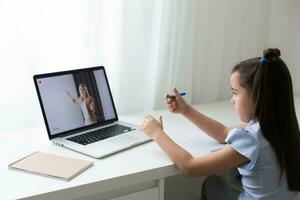 bella elegante scolara studiando compiti a casa matematica durante sua in linea lezione a casa, sociale distanza durante quarantena, auto-isolamento, in linea formazione scolastica concetto, casa schooler foto