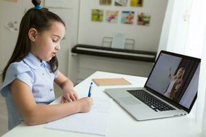 bella elegante scolara studiando compiti a casa matematica durante sua in linea lezione a casa, sociale distanza durante quarantena, auto-isolamento, in linea formazione scolastica concetto, casa schooler foto