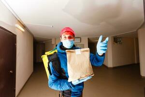 consegna uomo Spedire cibo Borsa a porta pomello per senza contatto o contatto gratuito a partire dal consegna ciclista nel davanti Casa per sociale distanziamento per infezione rischio. foto