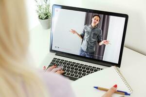 indietro Visualizza di femmina dipendente parlare parlare su video chiamata con diverso multirazziale colleghi su in linea riunione, donna lavoratore avere webcam gruppo conferenza con collaboratori su moderno il computer portatile a casa foto