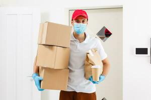 consegna uomo Tenere cartone scatole nel medico gomma da cancellare guanti e maschera. copia spazio. veloce e gratuito consegna trasporto . in linea shopping e esprimere consegna . quarantena foto