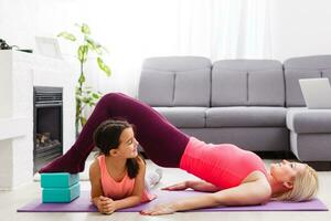 donna è fare in linea yoga con il computer portatile durante se stesso solitudine a sua vivente camera, no attrezzatura allenamento, meditazione suggerimenti per principianti. famiglia tempo con bambini, restare casa. foto