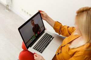 donna video conferenza con precettore su il computer portatile a casa. distanza formazione scolastica concetto. foto