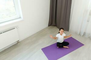 poco ragazza pratiche yoga a casa foto