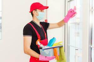 disinfezione per virus uccidere. lavoratore nel protezione maschera pulizia interno utilizzando chimico agenti per fermare diffusione virus infezioni. foto