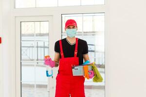 disinfezione per virus uccidere. lavoratore nel protezione maschera pulizia interno utilizzando chimico agenti per fermare diffusione virus infezioni. foto