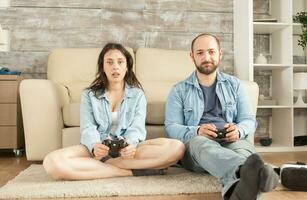 coppia avendo divertimento a casa giocando video Giochi con senza fili controllore. foto