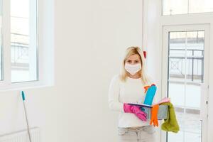 coronavirus. donna con viso maschera pulizia e disinfezione sua Casa durante coronavirus epidemico. prevenzione di covid-19 infezione. fermare coronavirus a partire dal diffusione. foto