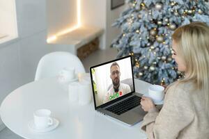 eccitato sorridente donna avere il computer portatile video Chiacchierare. giovane femmina a casa nel contento Natale umore. foto