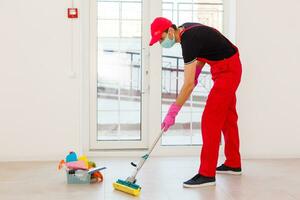 disinfezione per virus uccidere. lavoratore nel protezione maschera pulizia interno utilizzando chimico agenti per fermare diffusione virus infezioni. foto