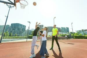 estate vacanze, sport e persone concetto contento famiglia con palla giocando su pallacanestro terreno di gioco foto