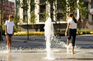 contento ragazzo giocando nel un' Fontana con acqua foto