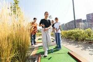 famiglia giocando mini golf su un' crociera rivestimento. bambino avendo divertimento con attivo tempo libero su vacanze. foto