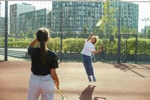 Due ragazze con badminton racchette su il calcio campo. foto