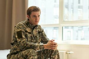 nervoso maschio militare sofferenza depressione, seduta solo a casa, ptsd concetto. foto