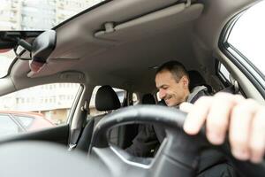 mio bambino. tiro di un' contento uomo seduta nel il suo auto toccante il pannello di controllo delicatamente sorridente allegramente foto