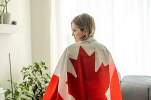 contento giovane donna con il bandiera di Canada su un' leggero bianca sfondo. ritratti canadese alunno femmina. foto