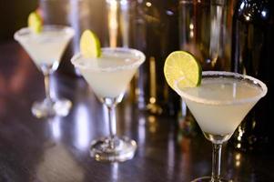 primo piano di bevande alla limonata in bicchieri da martini sul bar nel night club. chiudere l'alcol nel ristorante pub. concetto di cibo e bevande foto