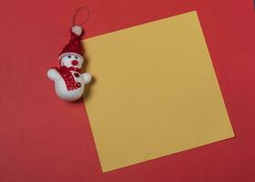 Natale saluto carta con pupazzo di neve su rosso sfondo. allegro Natale e contento nuovo anno foto