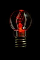 un' rosso leggero lampadina con un' nero sfondo foto