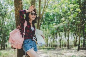 asiatica viaggiatrice stanca di perdersi nella foresta. donna che asciuga il sudore a mano. concetto di viaggio e avventura di una ragazza sola. tema ritratto e stile di vita. tema natura e calda estate foto