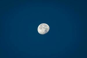 Luna durante giorno contro chiaro blu cielo foto