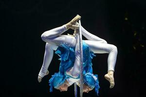 Due acrobata ragazze mostrare un' circo numero su un' buio sfondo. acrobatico prestazione. foto