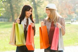 Due donne Tenere shopping borse nel il parco foto