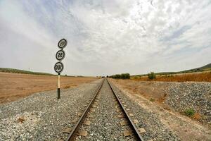 un' Ferrovia traccia con un' cartello su esso foto