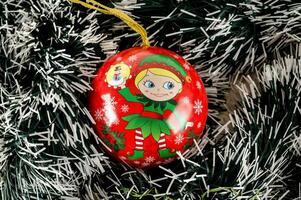 un' rosso e bianca Natale ornamento con un' poco elfo su esso foto