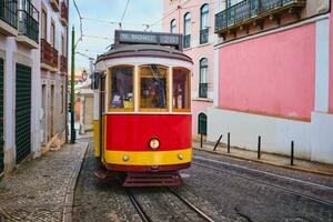 famoso Vintage ▾ giallo tram 28 nel il stretto strade di alfama quartiere nel Lisbona, Portogallo foto