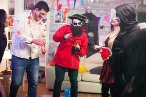 uomo con pirata costume Tenere un' birra a Halloween celebrazione con il suo gli amici. foto