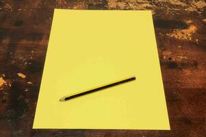 un' giallo foglio di carta con un' matita su superiore foto