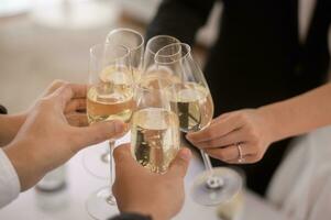 vicino su di mani Tenere bicchieri di Champagne a il nozze cerimonia foto