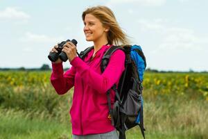 donna escursionista con binocolo nel natura foto