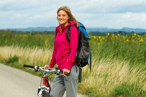 donna escursionista con un' bicicletta foto