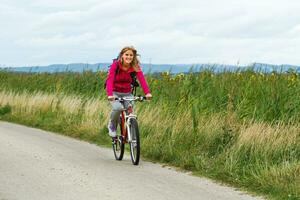 donna escursionista equitazione un' bicicletta. foto