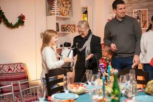 contento poco ragazza di sua presente a partire dal nonna a Natale famiglia cena. foto