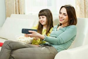 madre e figlia Guardando tv a loro casa foto