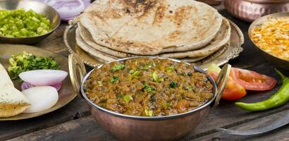 indiano cucina SEV tamatar su di legno tavolo foto