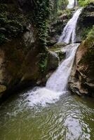 un' cascata nel il mezzo di un' foresta foto