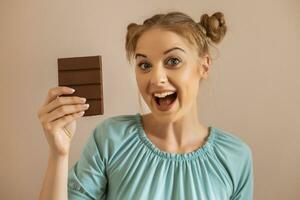 ritratto di contento carino donna gode mangiare cioccolato.tonico Immagine. foto