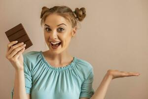 ritratto di contento carino donna gode mangiare cioccolato e gesticolando..tonico Immagine. foto