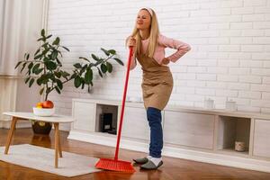 casalinga avendo dolore nel indietro mentre pulizia sua casa. foto