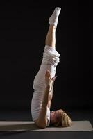 donna esercizio yoga interno su nero sfondo, foto