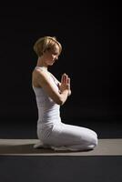 donna esercizio yoga interno su nero sfondo, foto