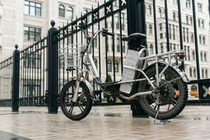 moderno elettrico bicicletta parcheggiata su città strada per consegna servizio foto